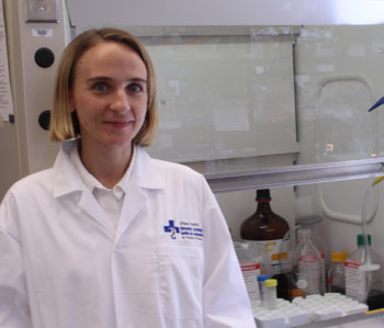 a person in a lab coat standing in front of a lab cabinet
