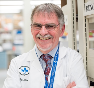 a person in a lab coat and tie standing next to a shelf