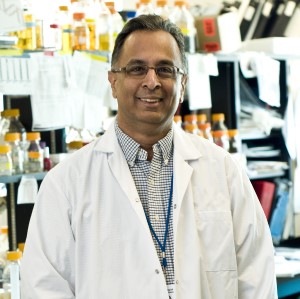 a person in a lab coat standing in front of a shelf