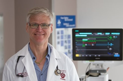 A doctor stands in a hospital room with medical equipment