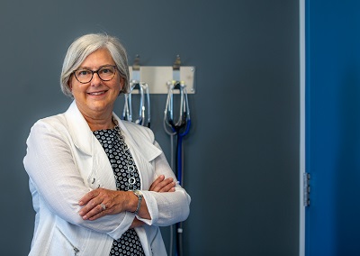 A woman in a white coat stands in a clinic.