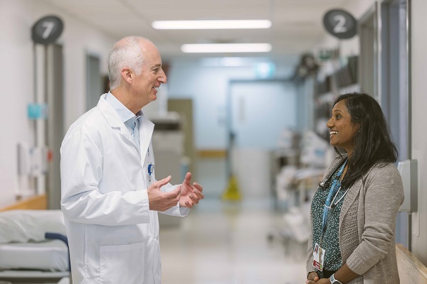 Two doctors talk in a hospital hallway