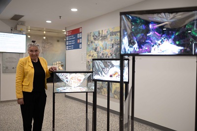Svetlana Swinimer standing next to her artwork.
