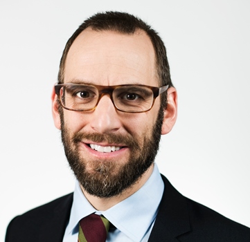 a person with glasses and a tie