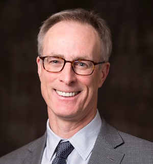 a person in a suit and tie smiling