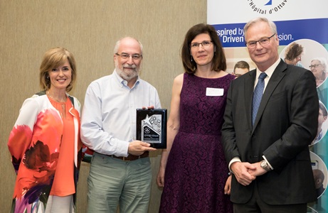 a group of people standing next to a banner