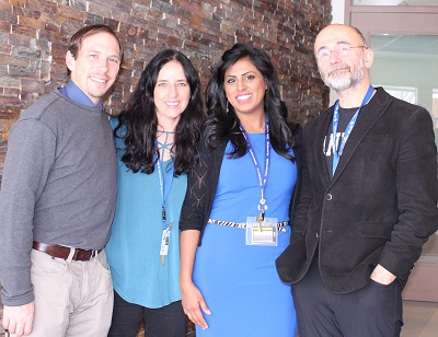 four people standing next to each other