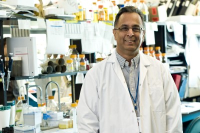 a person in a lab coat standing in front of a table