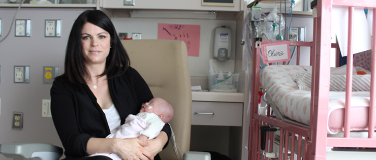 a person holding a baby in a hospital room