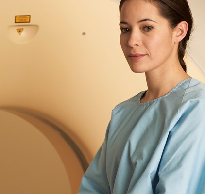 a person in a hospital gown is sitting on a bed