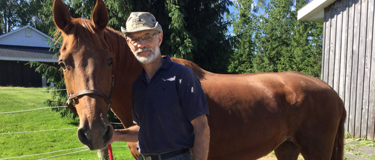 a person standing next to a horse in a field