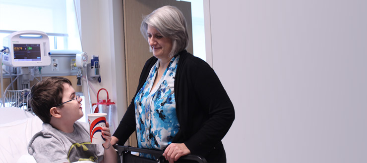 a person in a hospital room talking to a boy